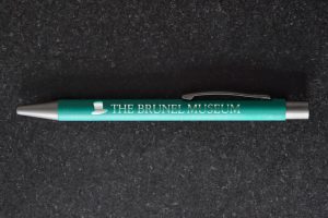 Green pen with a picture of a top hat and the words The Brunel Museum in silver