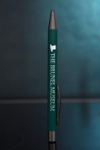 Green pen with a picture of a top hat and the words The Brunel Museum in silver