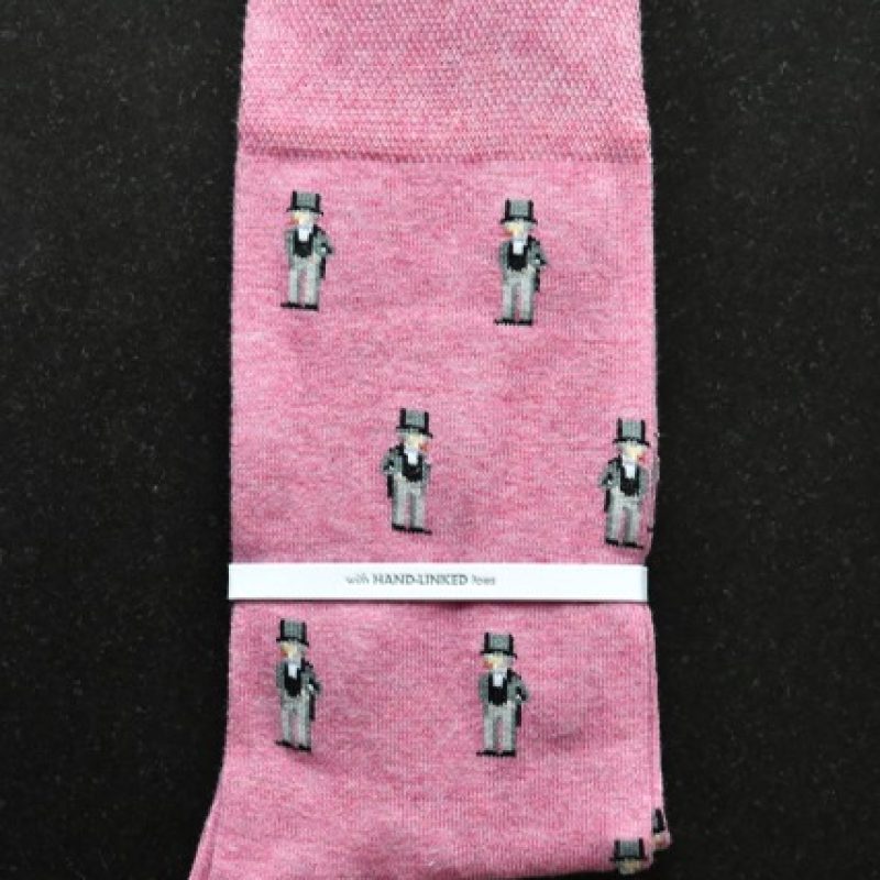 A pair of pink ankle socks with multiple small grey IKB figures.