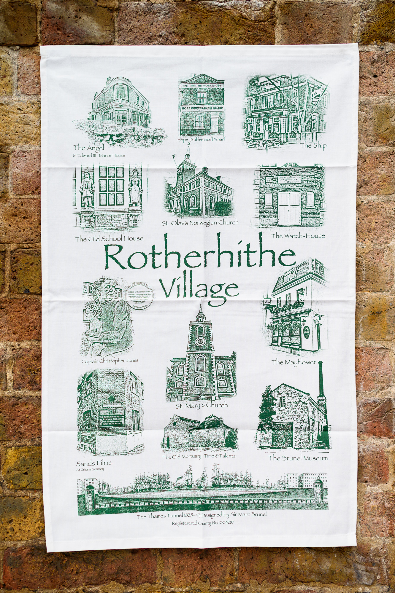 Tea Towel decorated with a selection of historic Rotherhithe buildings, green on white, including the Thames Tunnel at the bottom.