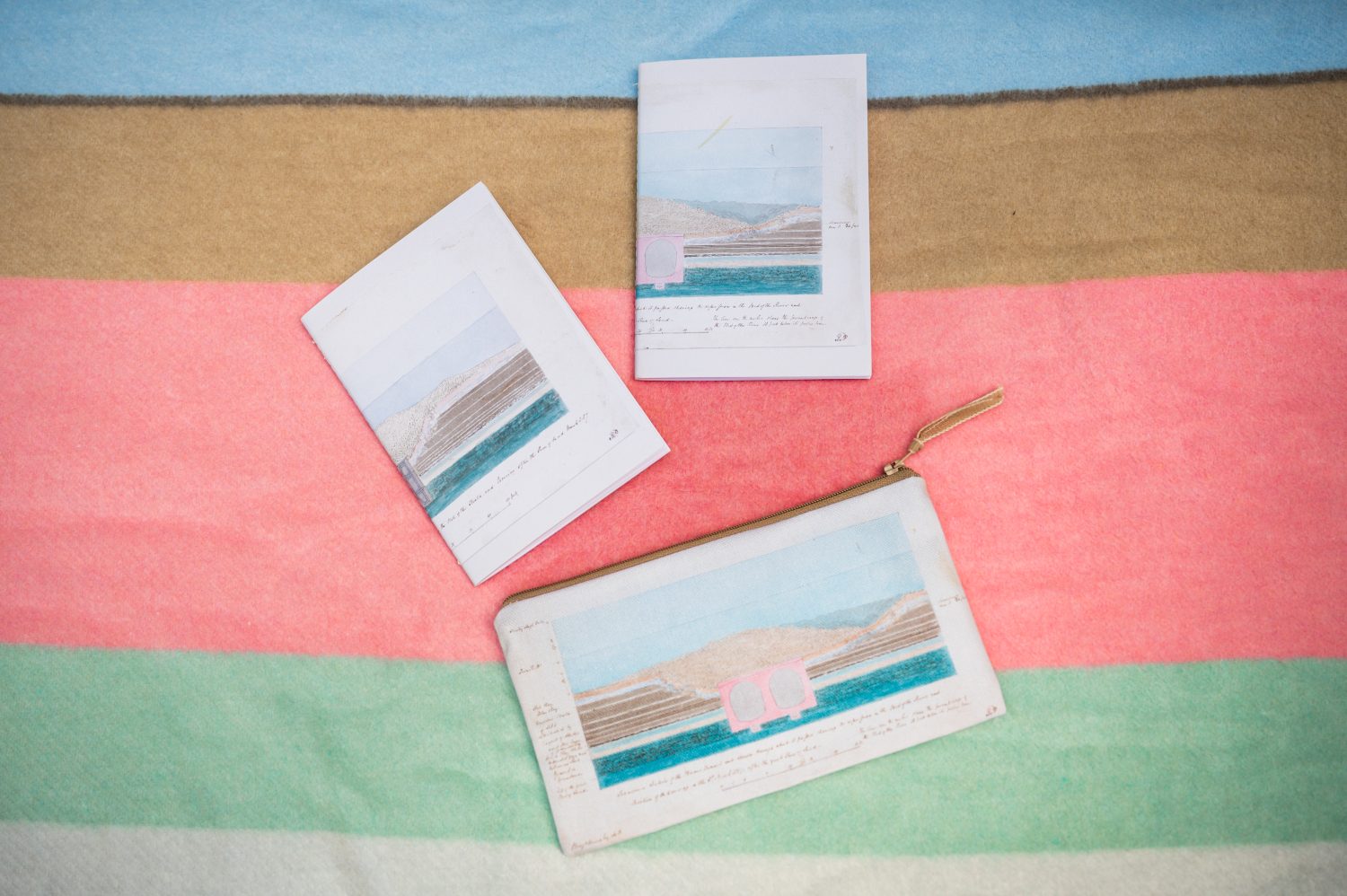 Image of two notebooks and a pencil case on a blanket