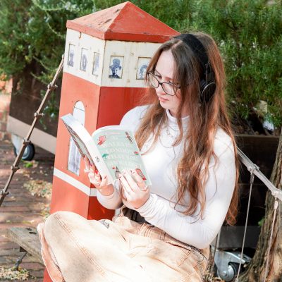 Image shows woman reading on a bench