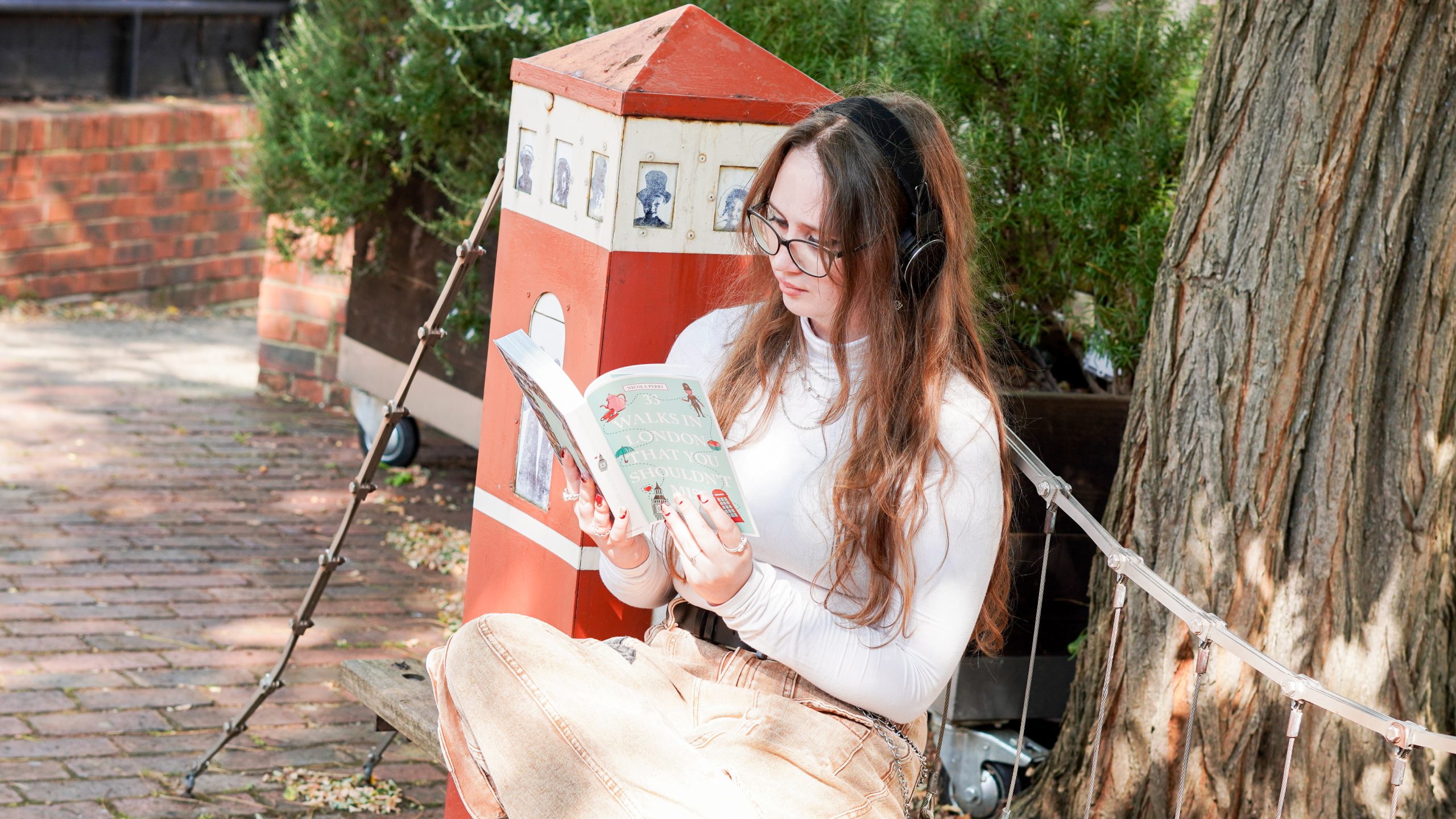 Image shows woman reading on a bench